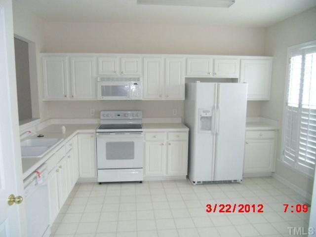 7111 Lovko Lane Raleigh, NC 27613 - Photo 4 of 8 a kitchen with white cabinets and white appliances
