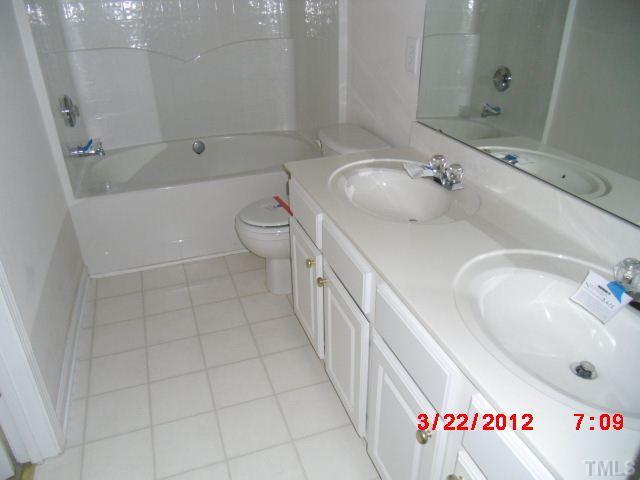 7111 Lovko Lane Raleigh, NC 27613 - Photo 6 of 8 a bathroom with a sink a toilet and shower