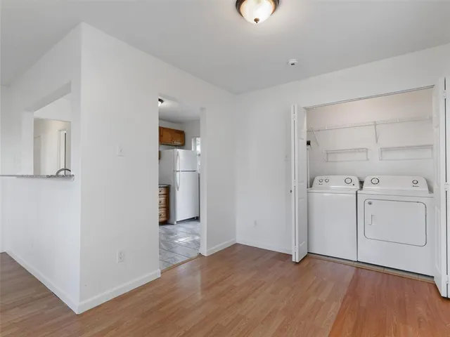 an empty room with wooden floor cabinet and window