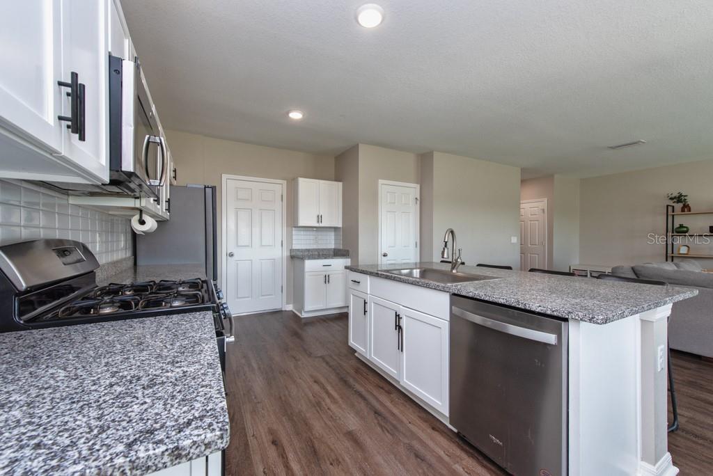 14617 Brumby Ridge Avenue Lithia, FL 33547 - Photo 13 of 46 a kitchen with stainless steel appliances granite countertop a sink stove and cabinets