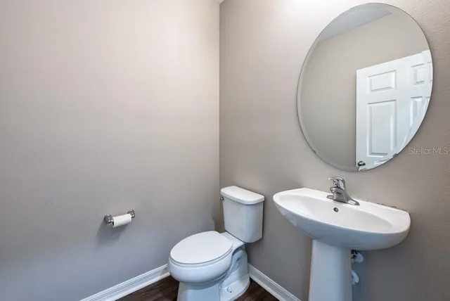 a bathroom with a toilet sink and mirror