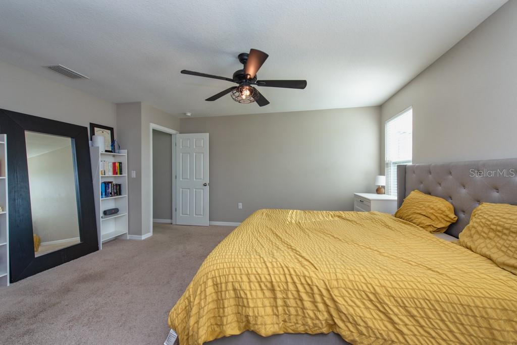 14617 Brumby Ridge Avenue Lithia, FL 33547 - Photo 20 of 46 a bedroom with a bed and a chandelier