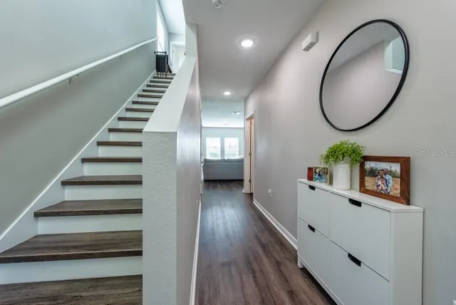 a view of a hallway with wooden floor and entryway