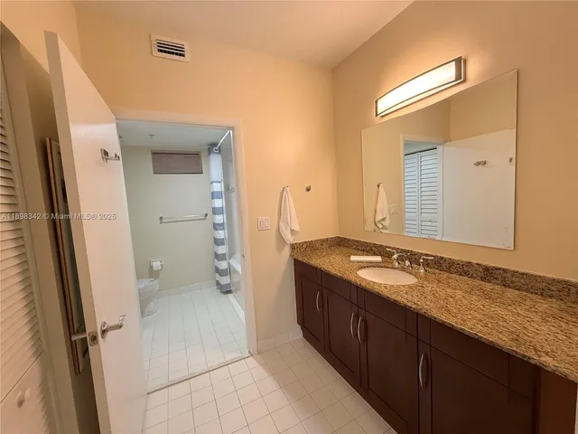 a spacious bathroom with a granite countertop sink and a mirror