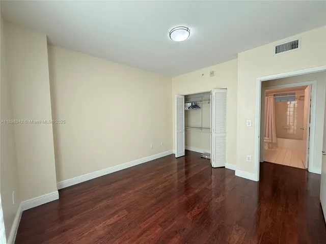 an empty room with wooden floor and closet