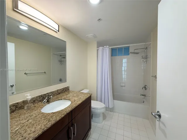 a bathroom with a granite countertop sink a toilet and shower