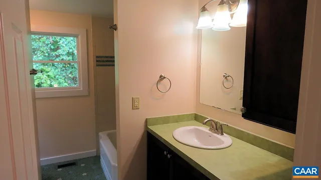 a bathroom with a granite countertop sink toilet and mirror