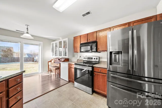 a kitchen with stainless steel appliances granite countertop a refrigerator stove and sink