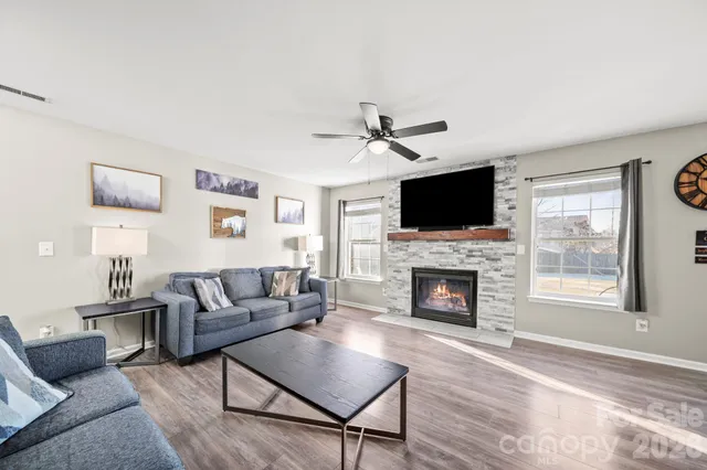 a living room with furniture a fireplace and a flat screen tv