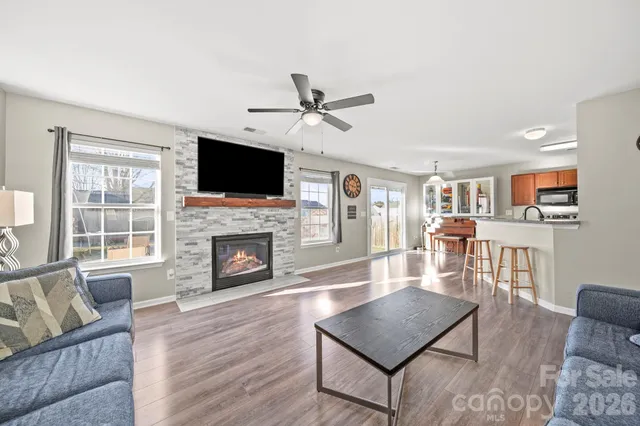 a living room with furniture a flat screen tv and a fireplace