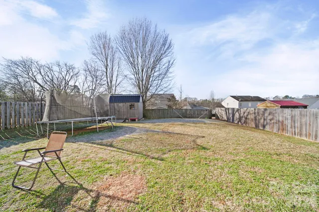 a swimming pool with lawn chairs and wooden fence