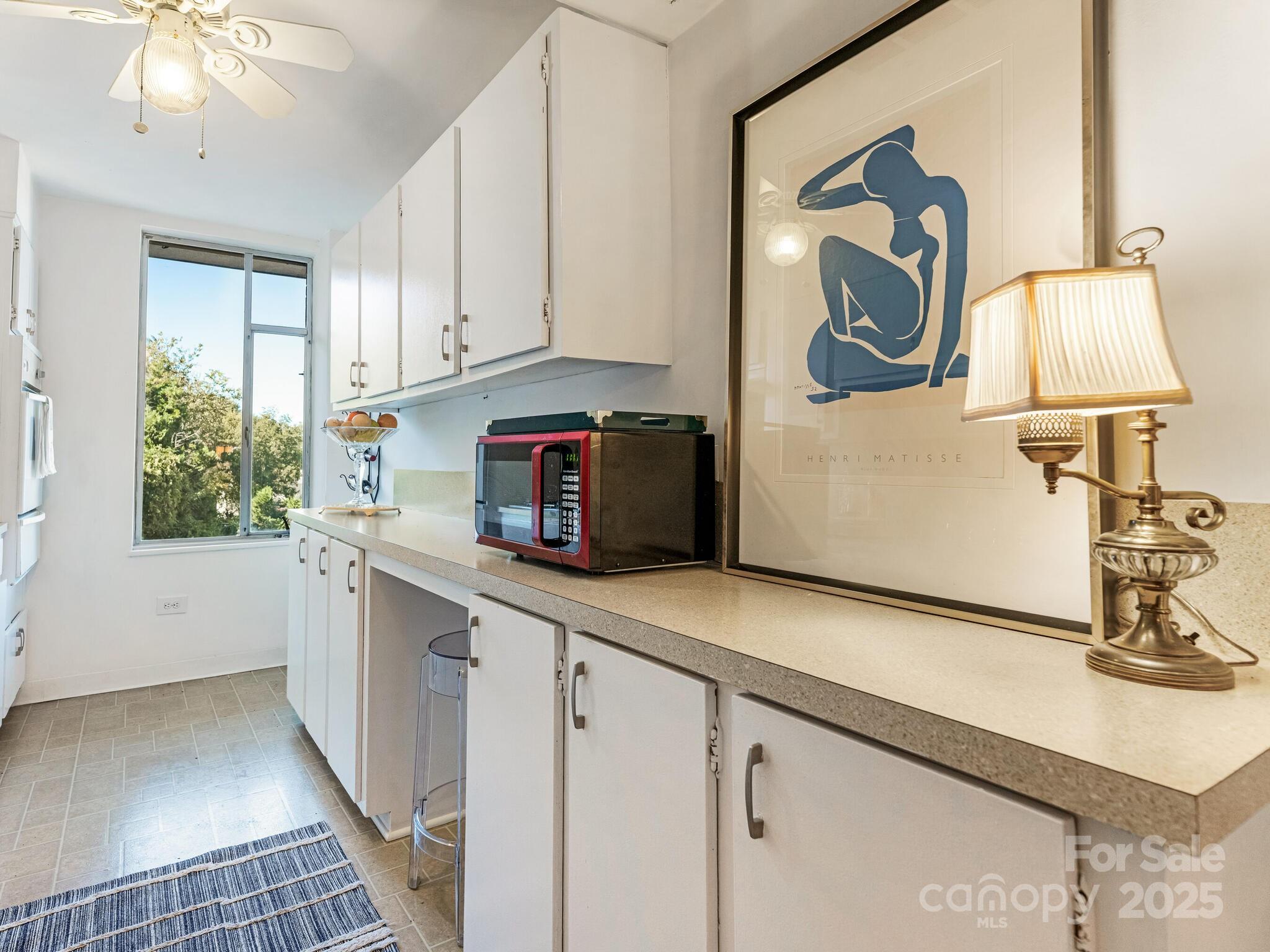 1300 Queens Road, Unit 401 Charlotte, NC 28207 - Photo 16 of 21 a kitchen with a sink cabinets and window