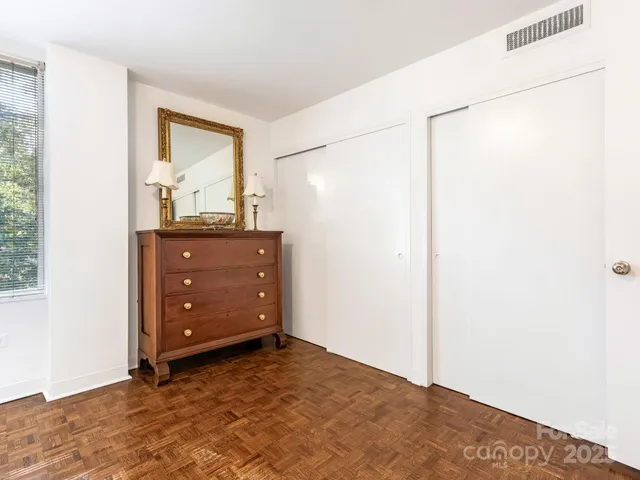a view of a bedroom with a dresser and mirror
