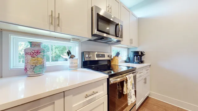 a kitchen with stainless steel appliances a microwave a stove and cabinets