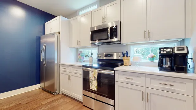 a kitchen with stainless steel appliances white cabinets and a sink