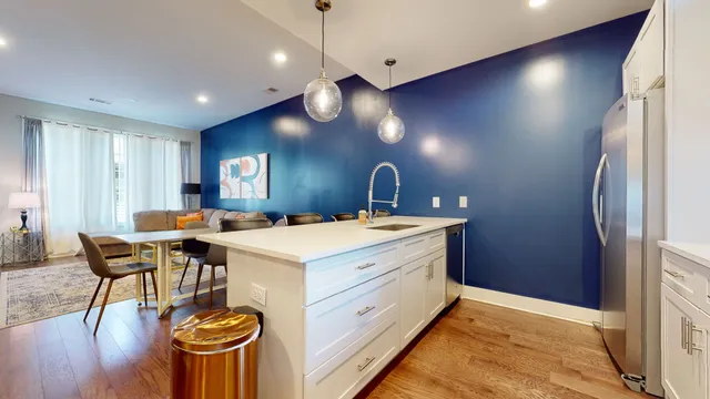 a kitchen with a stove a refrigerator and wooden floor