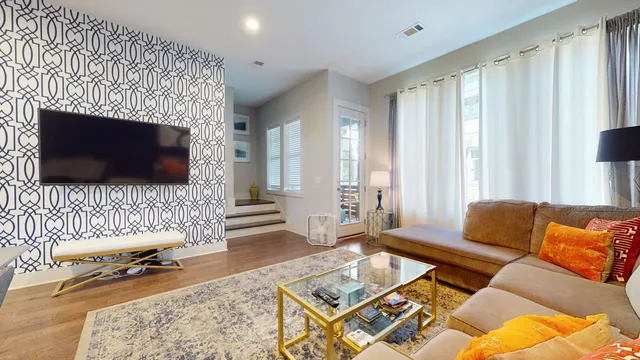 a living room with furniture a flat screen tv and a fireplace