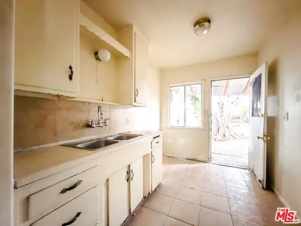 a kitchen with a sink a refrigerator and cabinets