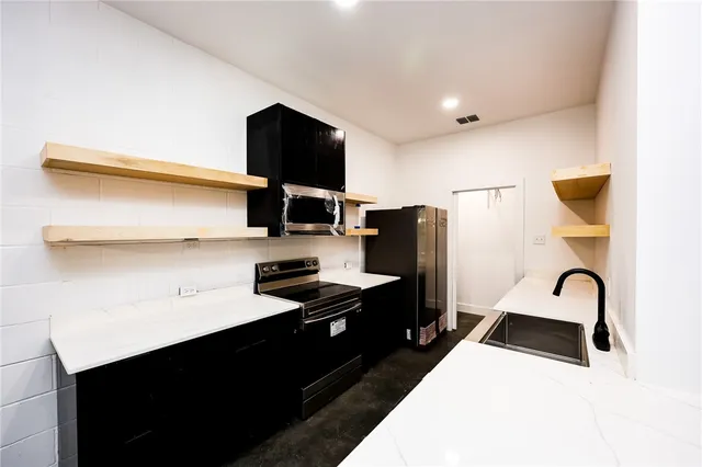 a kitchen with a sink a stove and a refrigerator