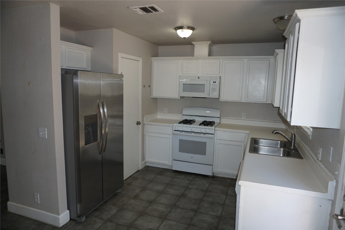 21218 Derby Day Avenue Pflugerville, TX 78660 - Photo 10 of 17 a kitchen with white cabinets and stainless steel appliances