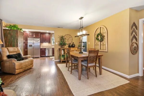 a dining room with furniture a chandelier and wooden floor