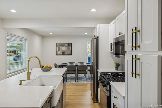 a kitchen with stainless steel appliances kitchen island a stove a sink a refrigerator and cabinets