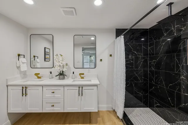 a bathroom with double vanity and a mirror
