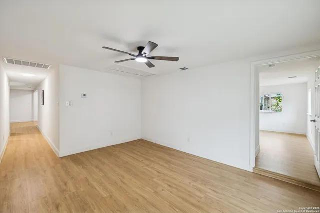 a view of a big room with wooden floor and a bathroom