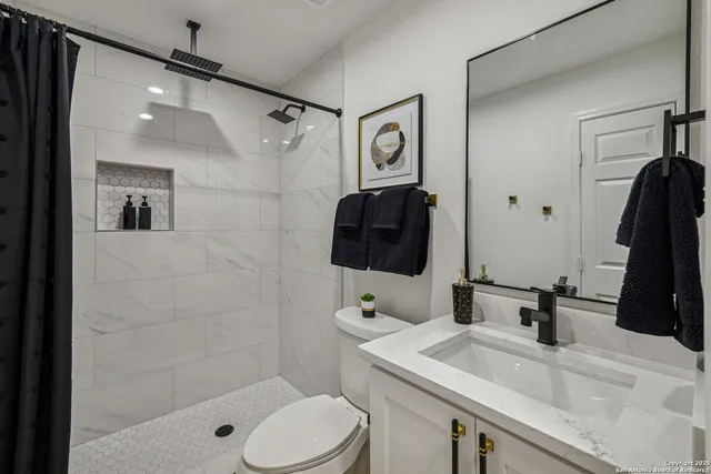 a bathroom with a sink a toilet and shower