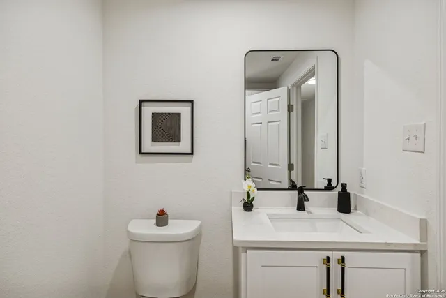 a bathroom with a sink toilet and mirror