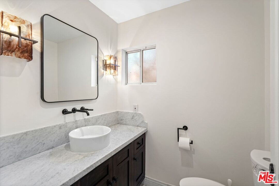 5324 Irvine Avenue Valley Village, CA 91601 - Photo 14 of 33 a bathroom with a granite countertop sink toilet and mirror