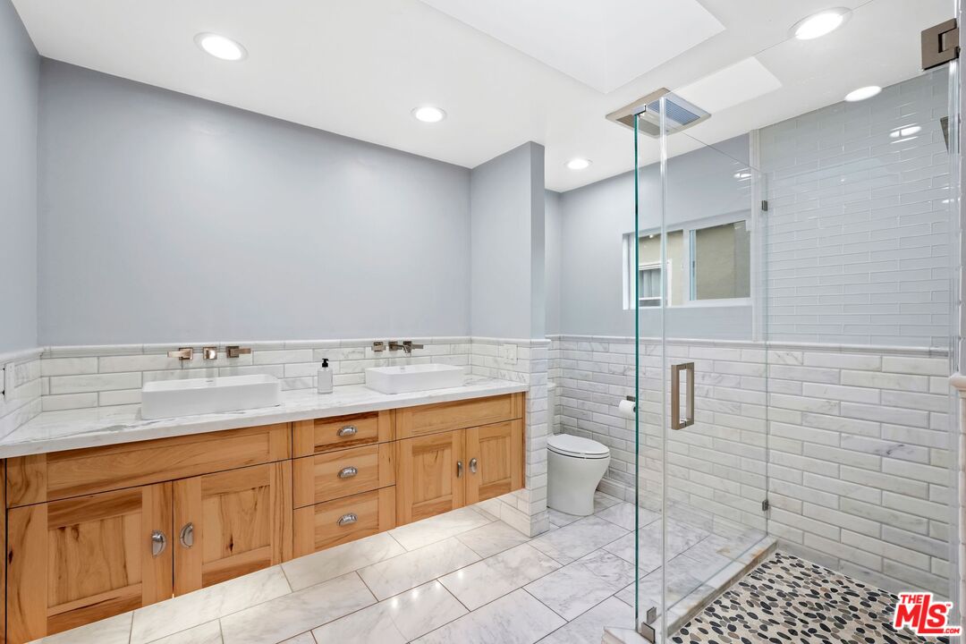 5324 Irvine Avenue Valley Village, CA 91601 - Photo 16 of 33 a bathroom with a granite countertop sink a toilet and shower