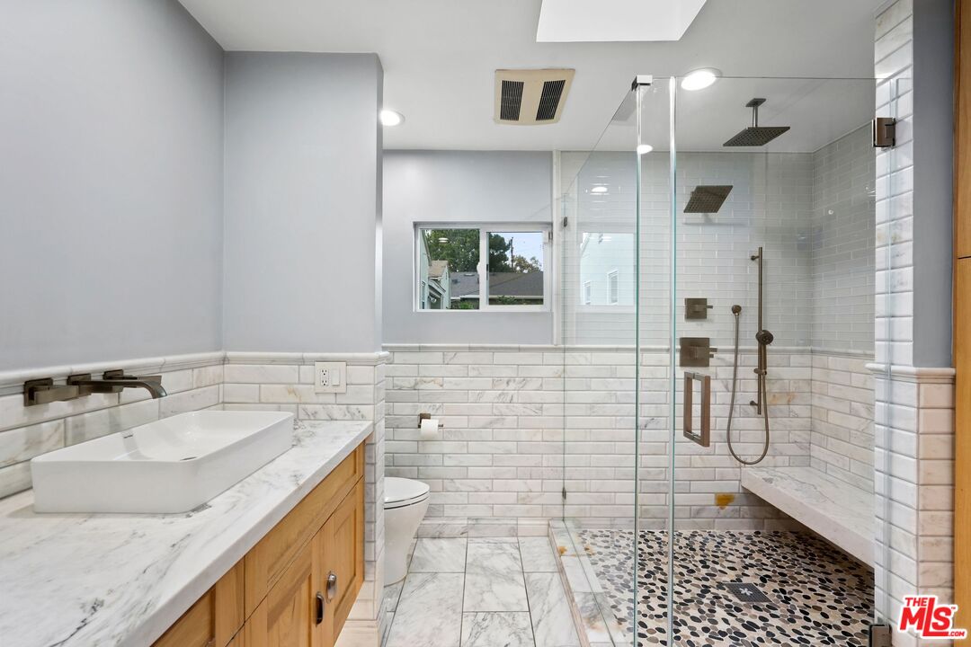 5324 Irvine Avenue Valley Village, CA 91601 - Photo 17 of 33 a bathroom with a granite countertop sink a toilet and shower