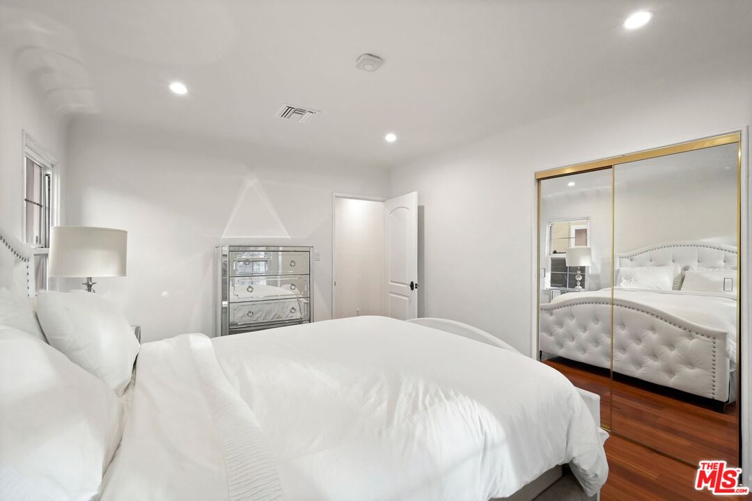 5324 Irvine Avenue Valley Village, CA 91601 - Photo 20 of 33 a bedroom with a large bed and wooden floor