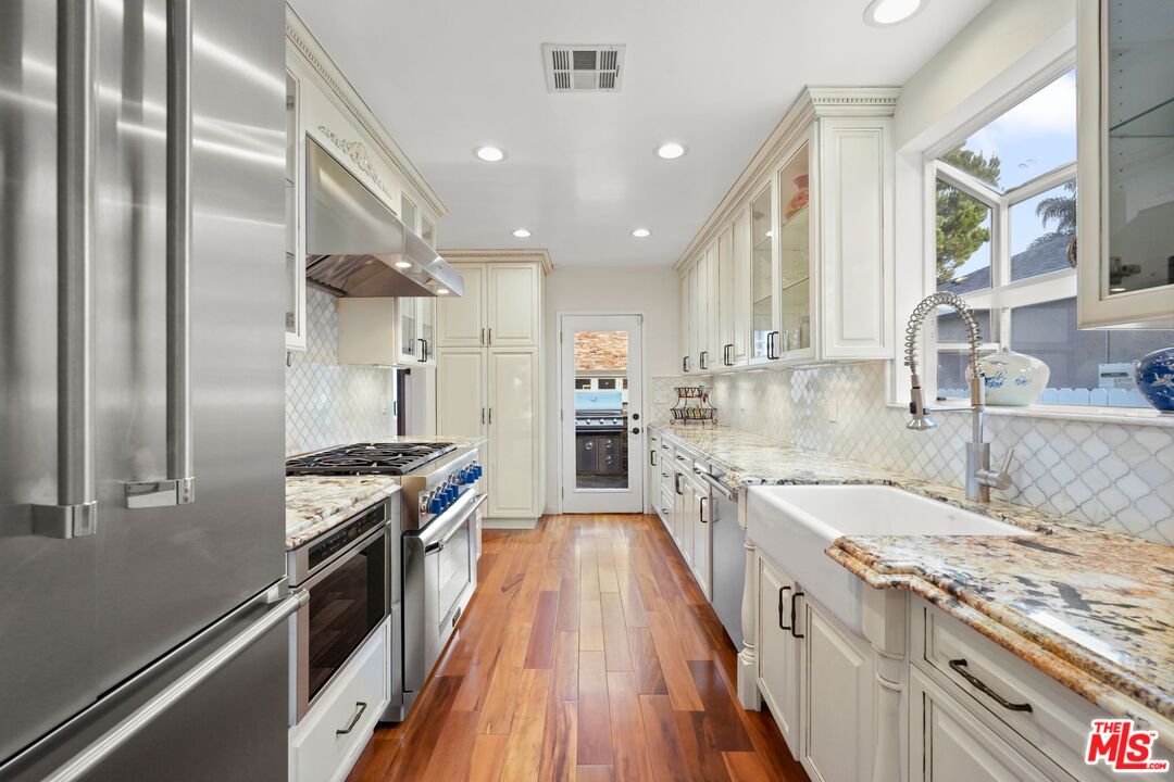 5324 Irvine Avenue Valley Village, CA 91601 - Photo 8 of 33 a kitchen with stainless steel appliances granite countertop a sink stove and refrigerator