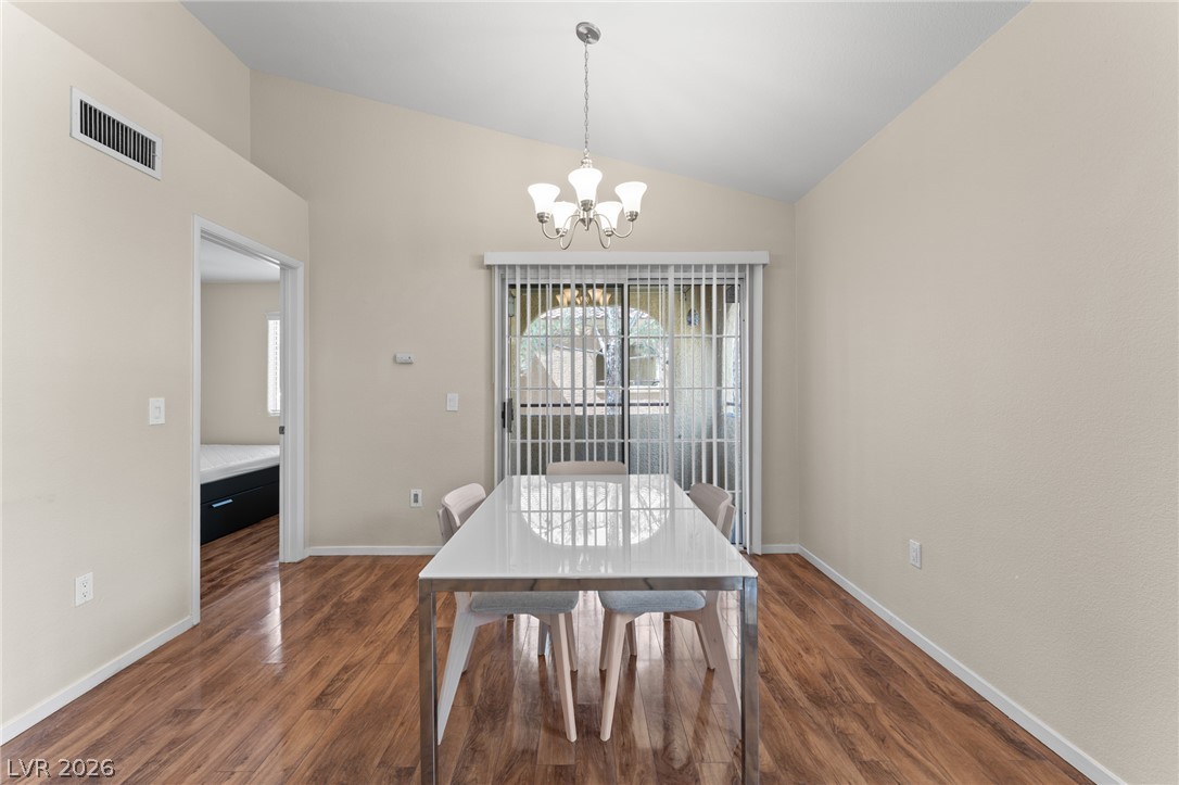 7950 West Flamingo Road, Unit 2142 Las Vegas, NV 89147 - Photo 11 of 24 A well-lit dining area featuring rich hardwood flooring and convenient sliding door access to outdoor space.