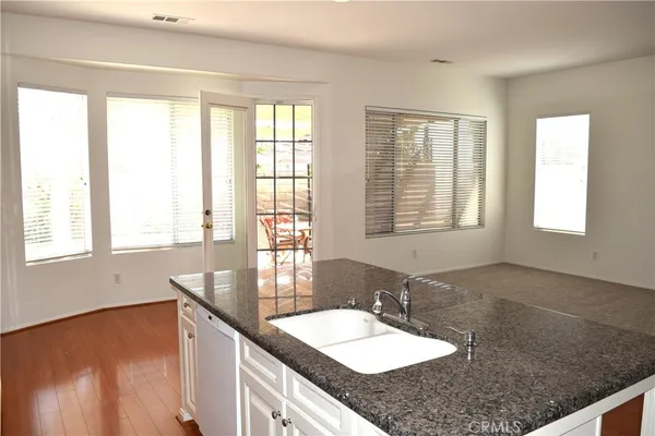 a bathroom with a granite countertop sink and a window