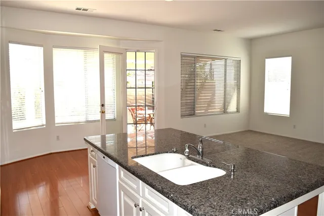 a bathroom with a granite countertop sink and a window