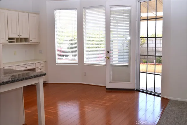 a view of a kitchen with wooden floor and a window