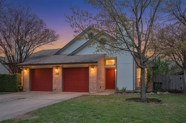 a front view of a house with a yard and tree s