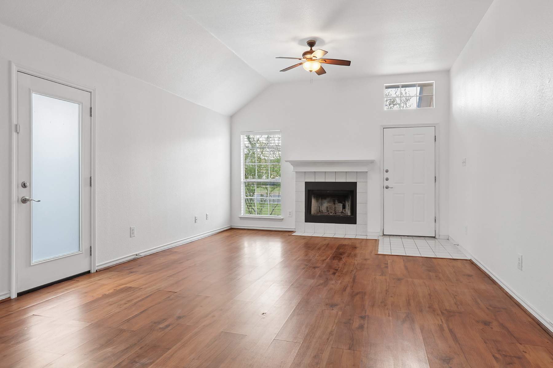 12319 Turtle Rock Road, Unit B Austin, TX 78729 - Photo 4 of 26 an empty room with wooden floor chandelier fan and windows
