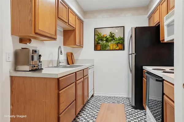 a kitchen with stainless steel appliances a sink a stove a refrigerator a cabinets and a window