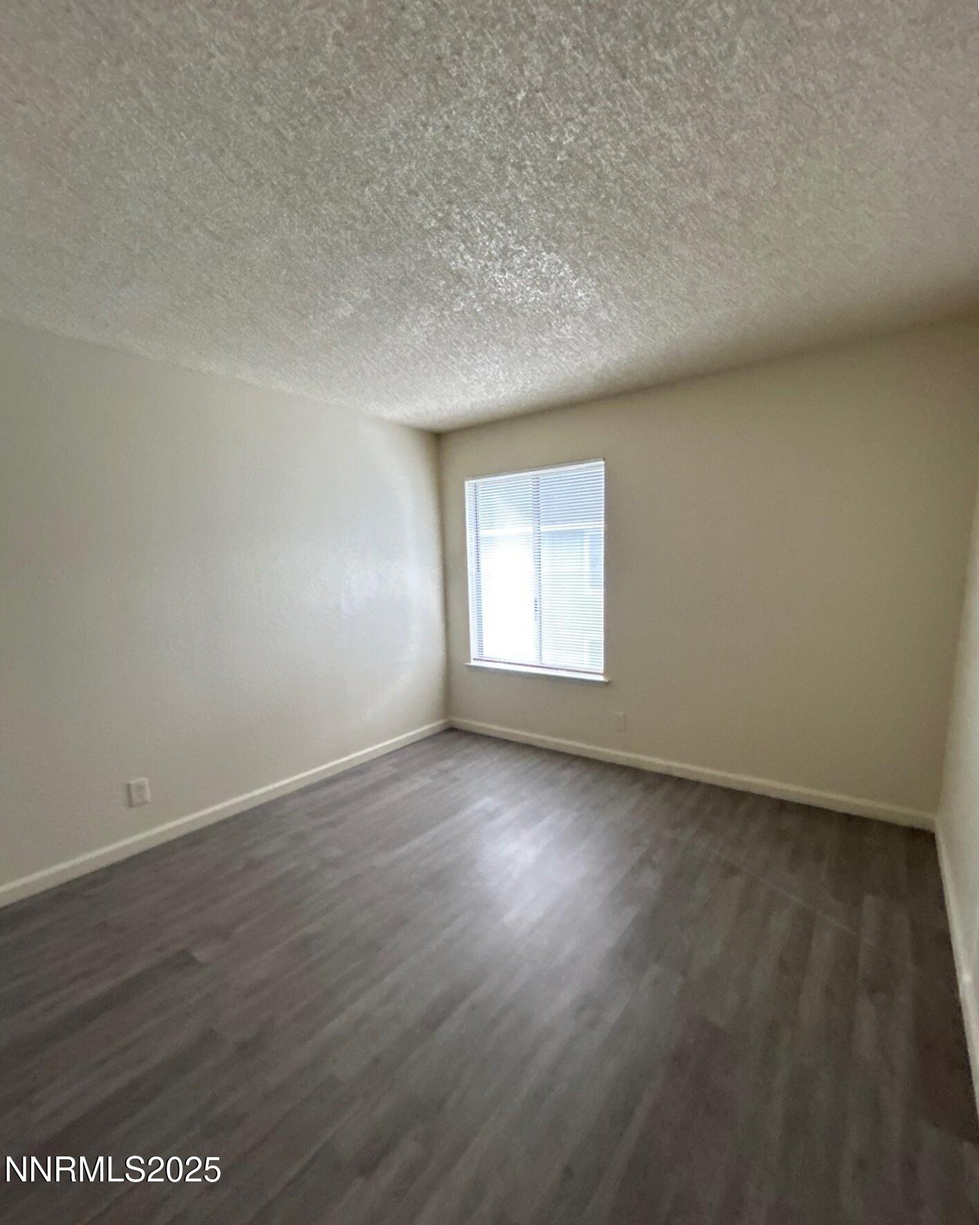 4604 Neil Road, Unit 98 Reno, NV 89502 - Photo 11 of 16 an empty room with wooden floor and windows