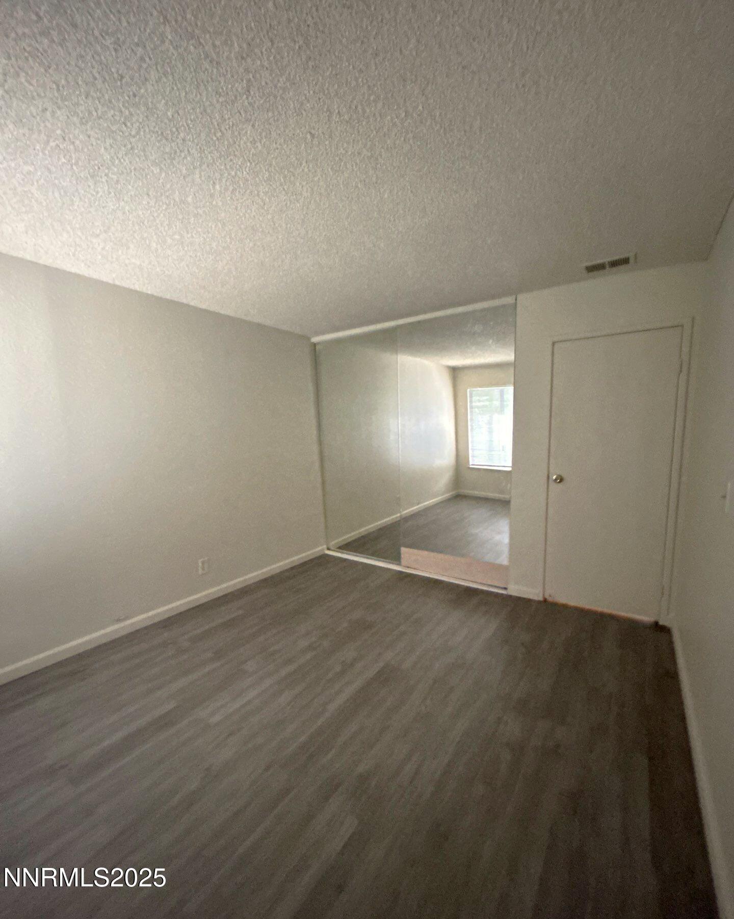 4604 Neil Road, Unit 98 Reno, NV 89502 - Photo 15 of 16 an empty room with wooden floor and windows