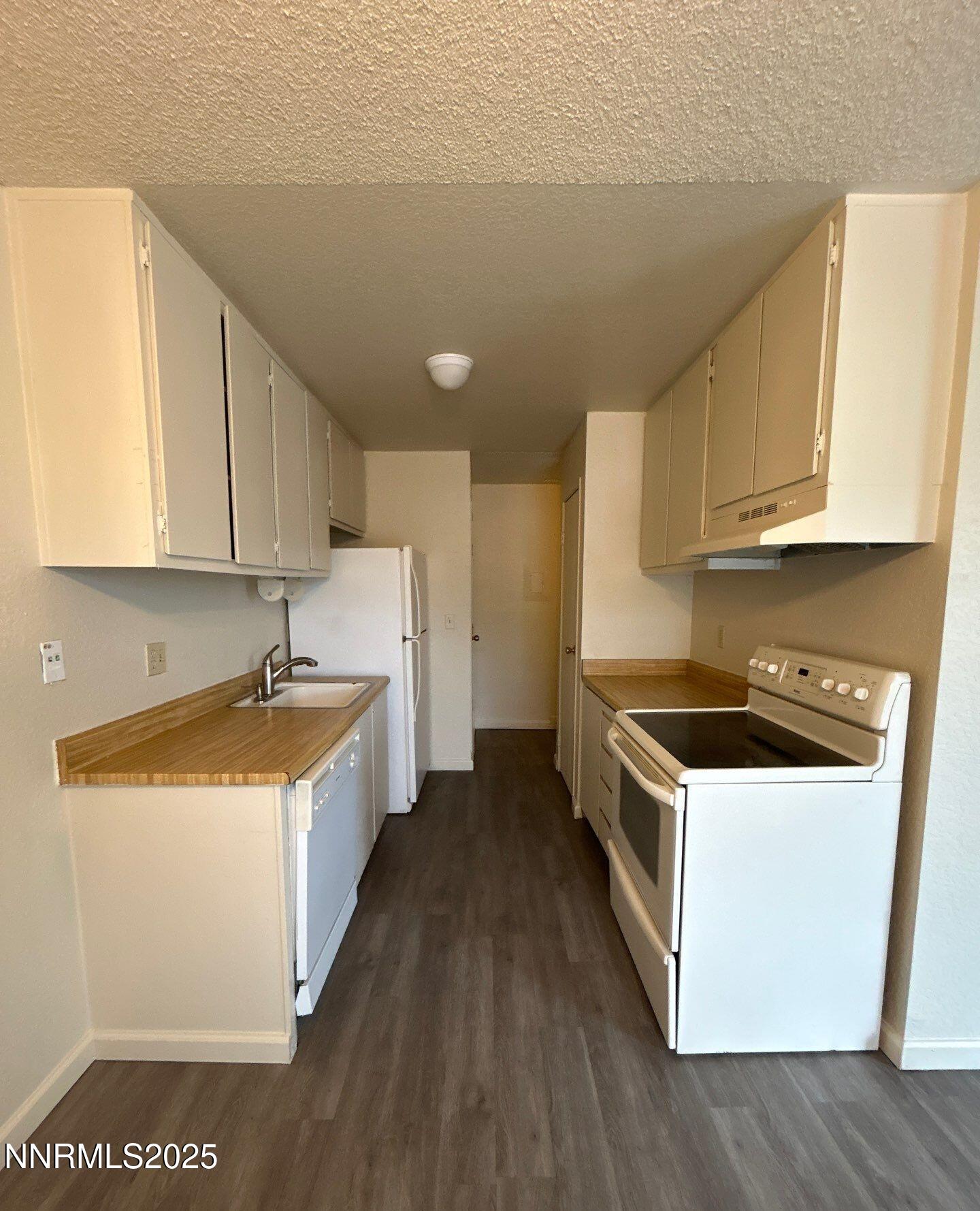 4604 Neil Road, Unit 98 Reno, NV 89502 - Photo 3 of 16 a kitchen with a stove a sink and a refrigerator