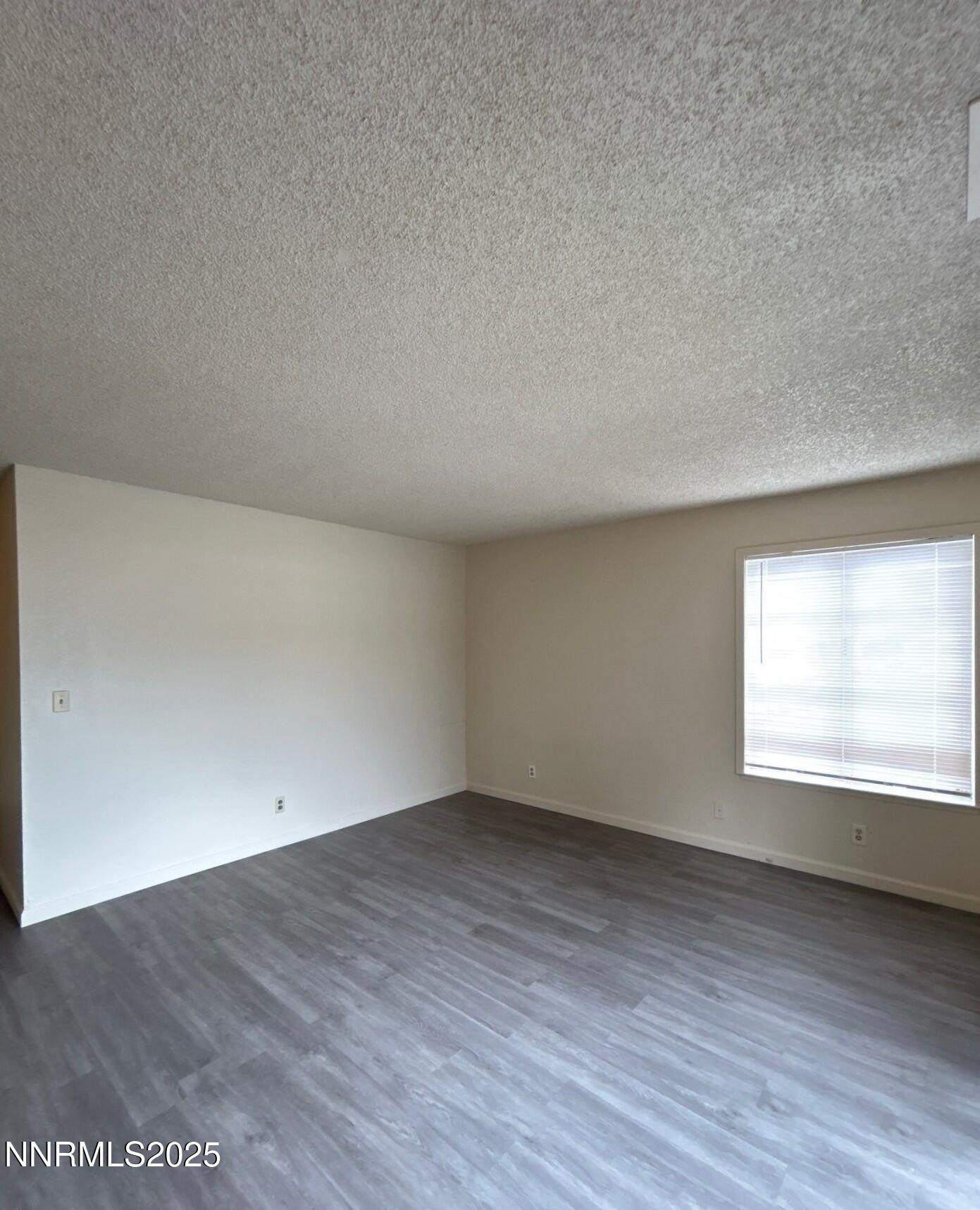 4604 Neil Road, Unit 98 Reno, NV 89502 - Photo 8 of 16 an empty room with wooden floor and windows