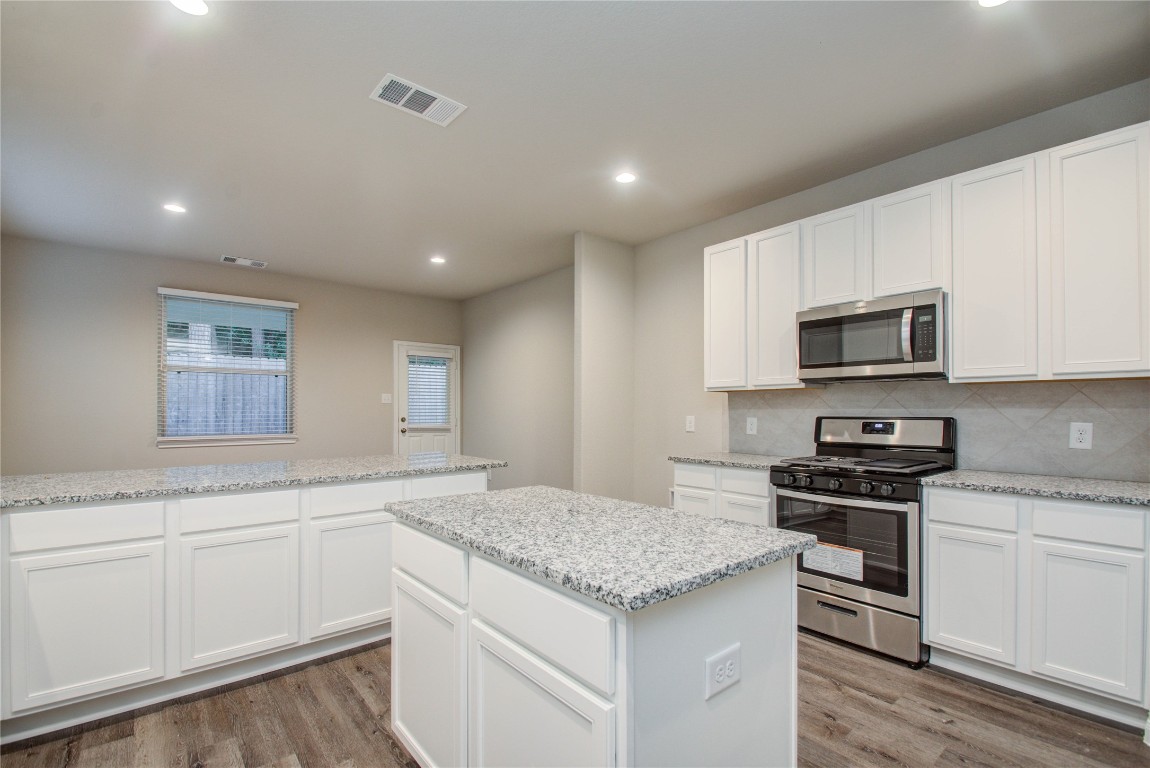 3620 Cub Drive Conroe, TX 77301 - Photo 12 of 49 a kitchen with granite countertop white cabinets and stainless steel appliances