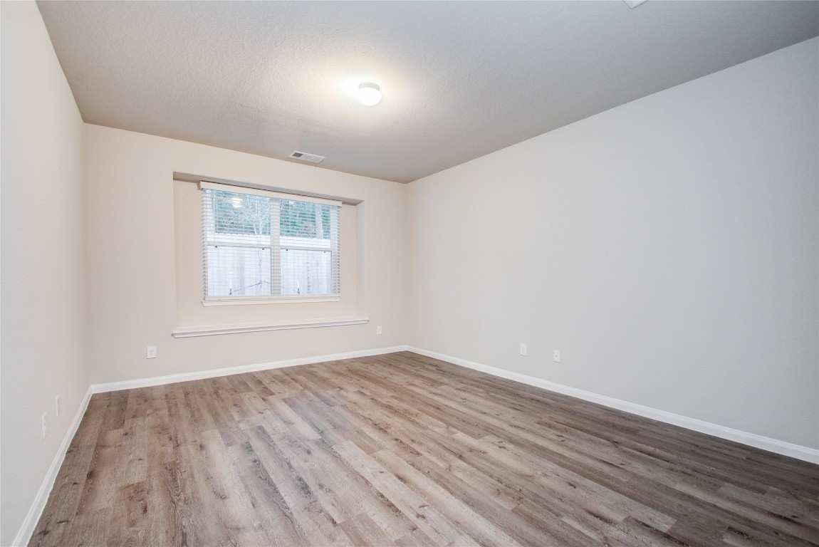 3620 Cub Drive Conroe, TX 77301 - Photo 16 of 49 an empty room with wooden floor and windows