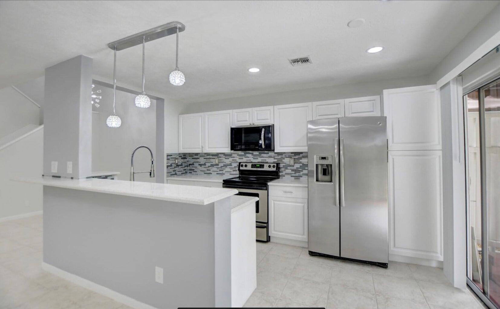 a kitchen with stainless steel appliances a refrigerator sink and stove