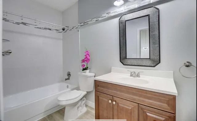 a bathroom with a sink vanity mirror and toilet